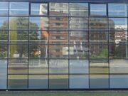 façade constituée d'un mur rideau avec reflet du bâtiment annulaire situé en face